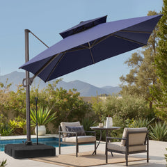 Tilted 10x10 ft square navy blue cantilever patio umbrella with wheeled base shading a poolside seating set