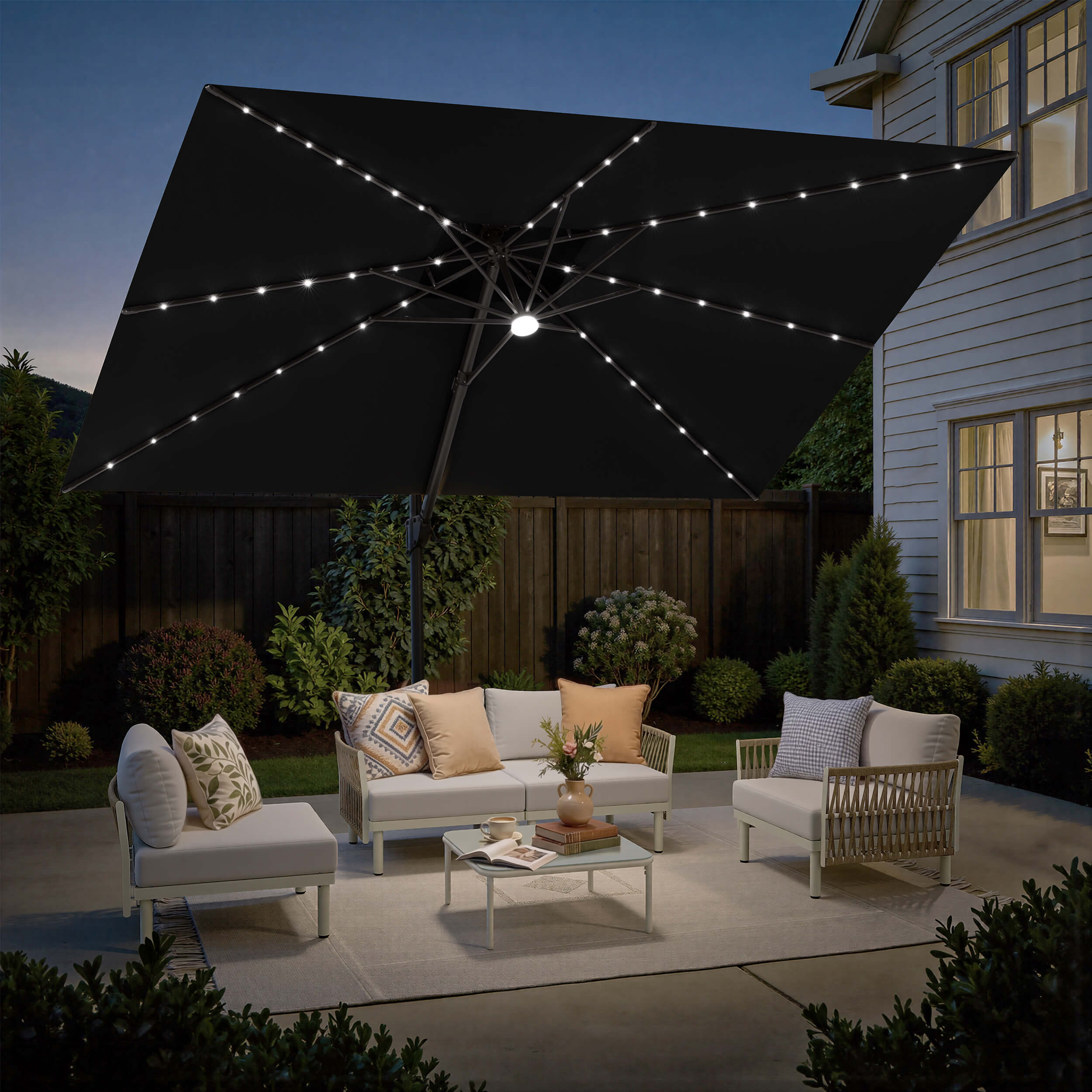 Lighted Crestlive 12x9 ft black cantilever umbrella with cross base shading a patio sofa set at night