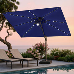 Tilted 12x9 ft navy blue lighted cantilever umbrella with heavy-duty base shading poolside lounge chairs at sunset