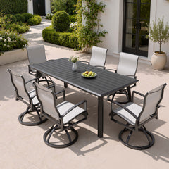 7-piece patio dining set with aluminum expandable table and 6 Sunbrella swivel rockers on patio.