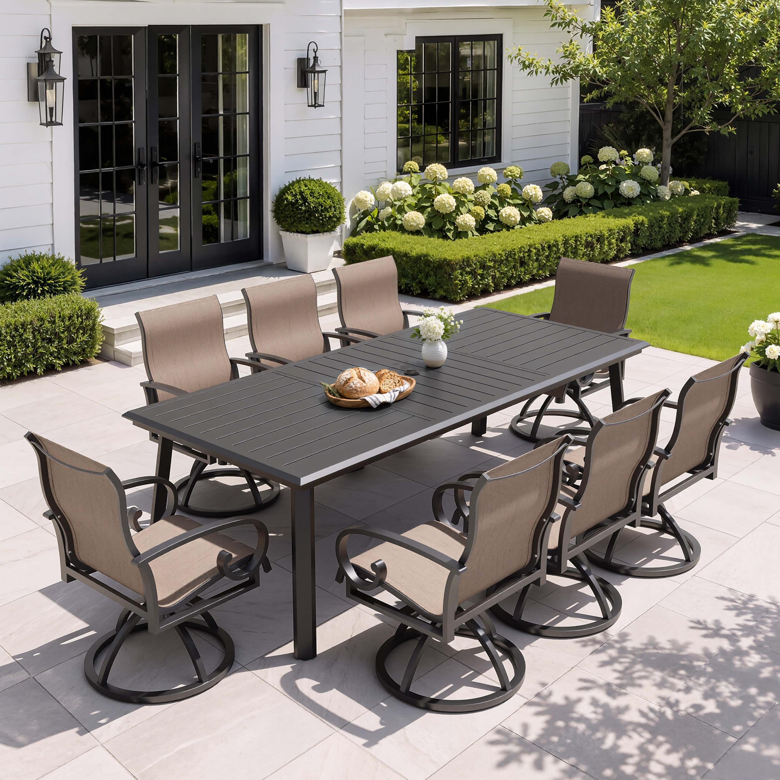 9-piece patio dining set with aluminum expandable table and 8 swivel Sunbrella chairs on patio.