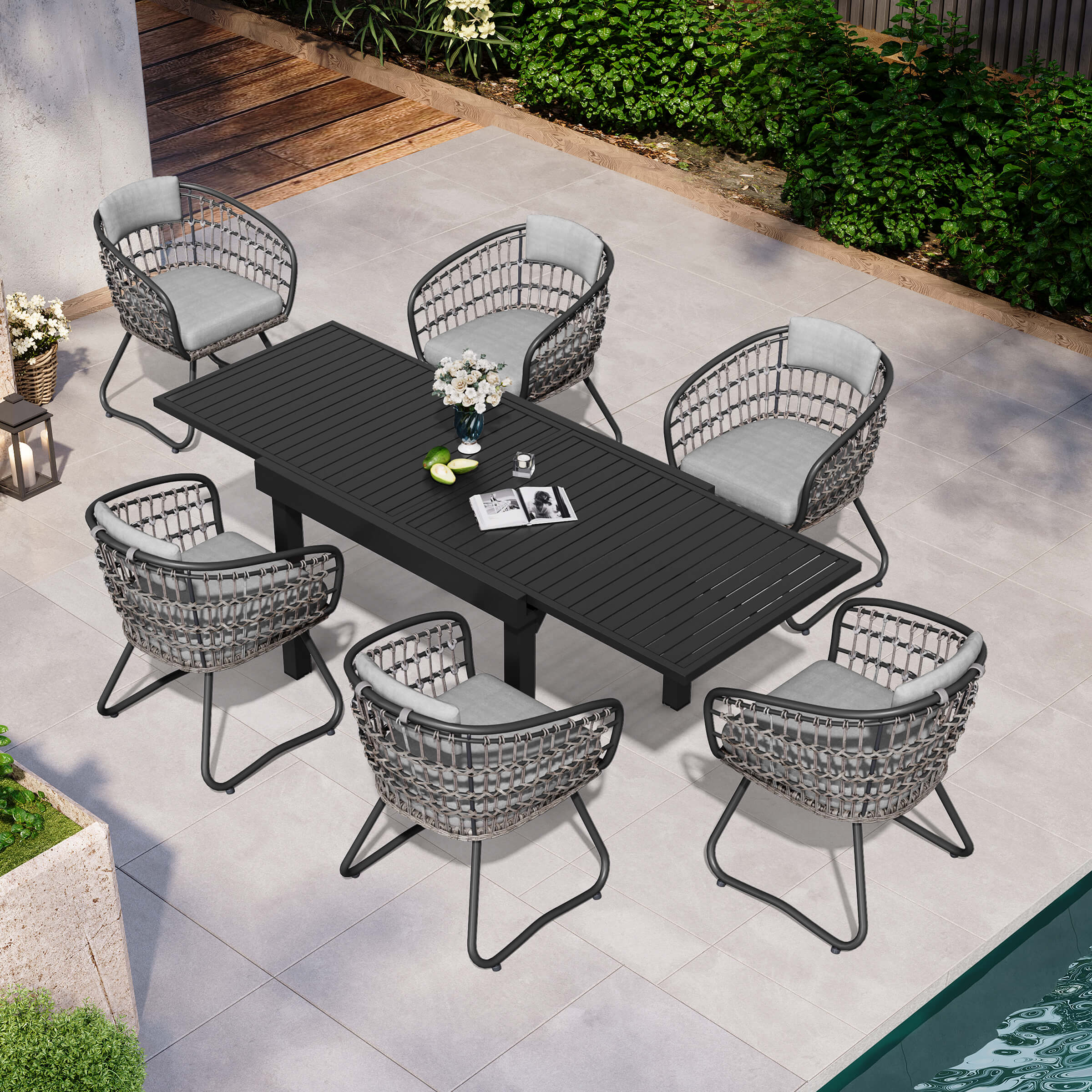 7-piece expandable patio dining set with black aluminum table and 6 grey PE rattan chairs poolside.