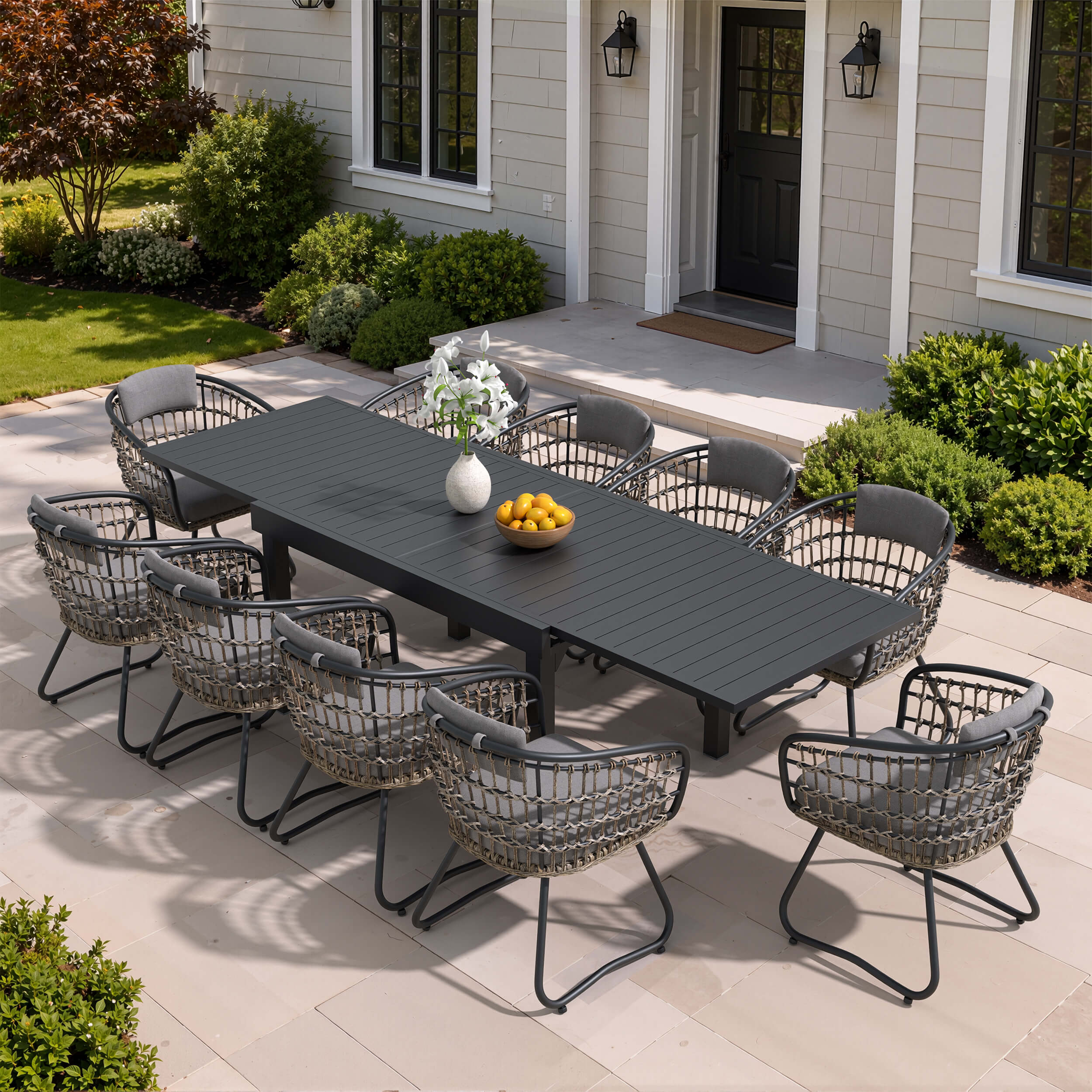 11-piece expandable patio dining set with black aluminum table and 10 grey PE rattan chairs on patio.